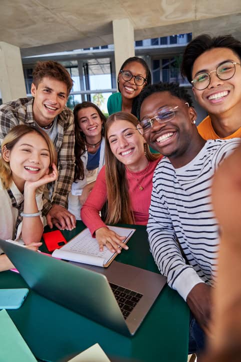 Group of diverse students taking a selfie while gathering to study together at campus stock photo